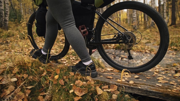 The woman travel on mixed terrain cycle touring with bikepacking. The traveler journey with bicycle bags. Sport tourism bikepacking.