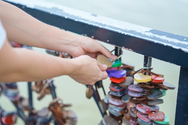 Woman Traveler hand lock key during travel in Da Nang Tourist sightseeing at love lock bridge Landmark and popular Vietnam and Southeast Asia travel concept