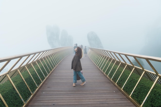 Woman Traveler sightseeing Golden bridge at the top of the Ba Na Hills Landmark and popular Vietnam and Southeast Asia travel concept