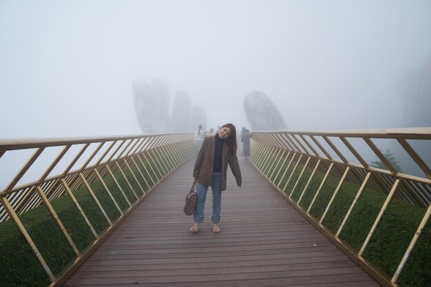 Woman Traveler sightseeing Golden bridge at the top of the Ba Na Hills Landmark and popular Vietnam and Southeast Asia travel concept