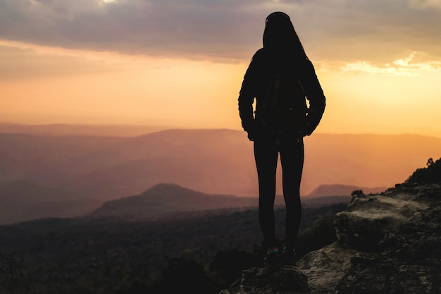 Woman traveler standing on top of the mountain and taking photo view of nature on holiday.