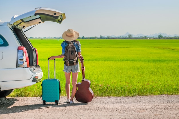 Woman traveler towing baggage and walking on the road. 