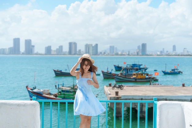 Woman traveler visiting at Son Tra marina Tourist with blue dress and hat traveling in Da Nang city Vietnam and Southeast Asia travel concept