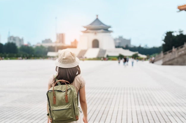 Woman traveler visiting in Taiwan Tourist with backpack sightseeing in National Chiang Kai shek Memorial or Hall Freedom Square Taipei City landmark and popular attractions Asia Travel concept