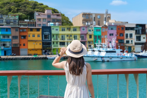 Woman traveler visiting in Taiwan Tourist with hat sightseeing in Keelung Colorful Zhengbin Fishing Port landmark and popular attractions near Taipei city Asia Travel concept