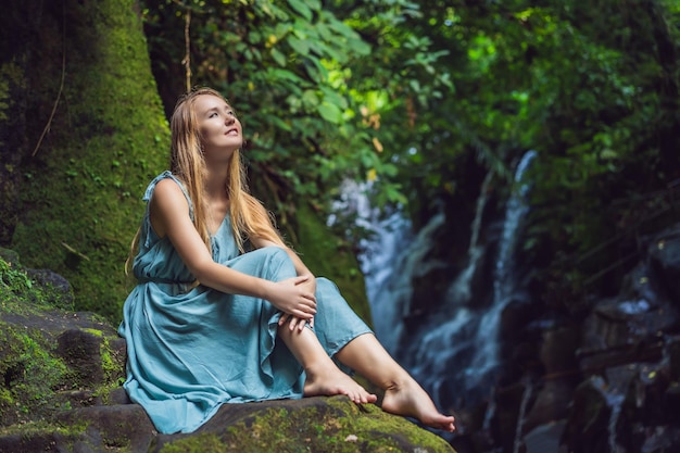 Woman traveler on a waterfall background Ecotourism concept