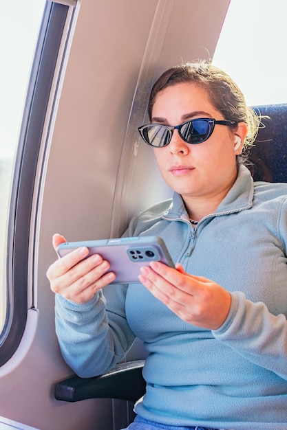 Woman traveling by train working on smart phone