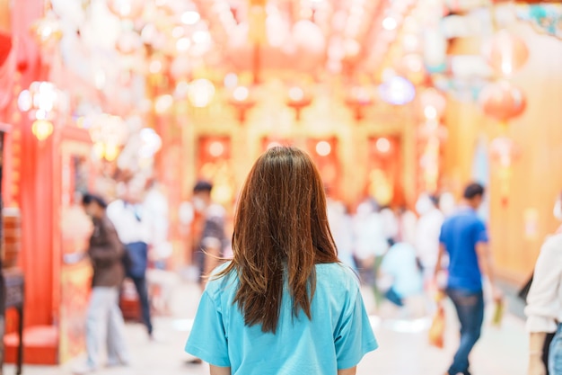 Woman traveling in Wat Mangkorn Kammalawas Leng Nuei Yee as Chinese temple Asian traveler visiting at Yaowarat road or Chinatown of Bangkok landmark and popular for tourist attractions in Thailand