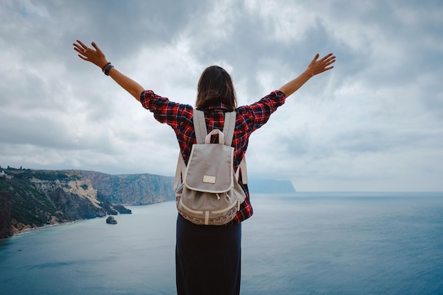 Woman traveling with backpack tourist on seashore in summer