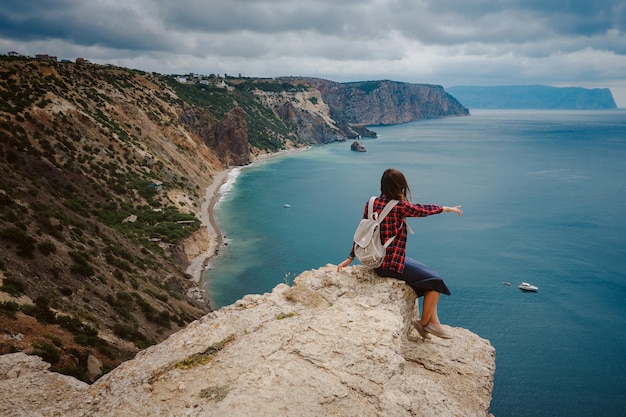 Woman traveling with backpack tourist on seashore in summer