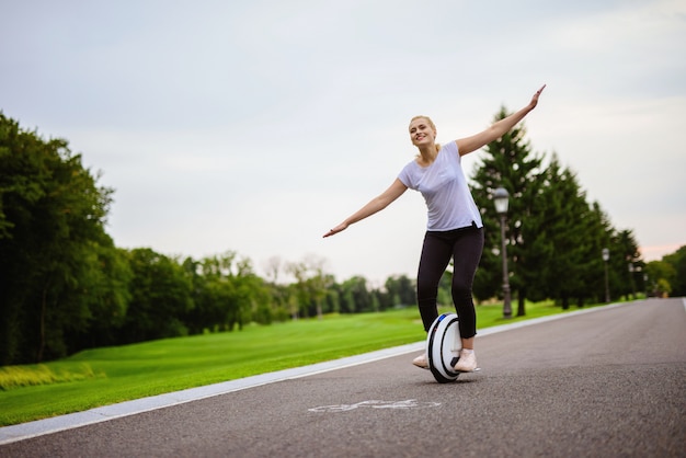 Woman tries to keep her balance on monowheel.