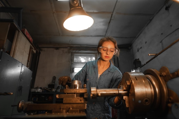 Woman turner in production near the lathe Profession concept Turner Metalworking Turning Industry Metal