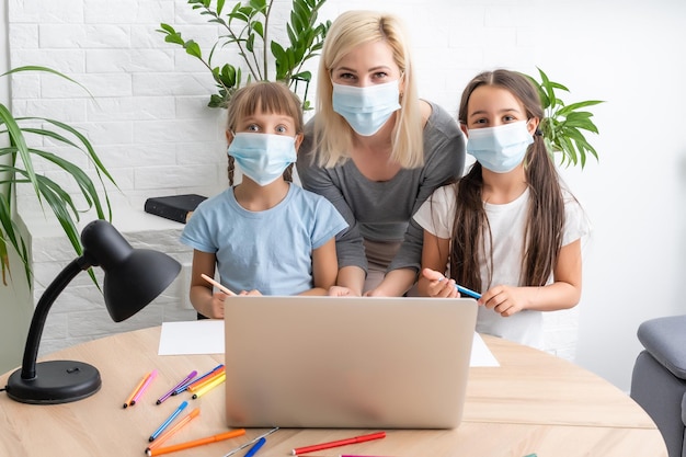 Woman tutor or foster parent mum helping cute caucasian school child girl doing homework sitting at table. Diverse nanny and kid learning writing in notebook studying at home.