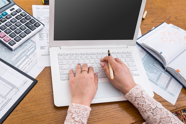 Woman typing on laptop and filling 1040 form