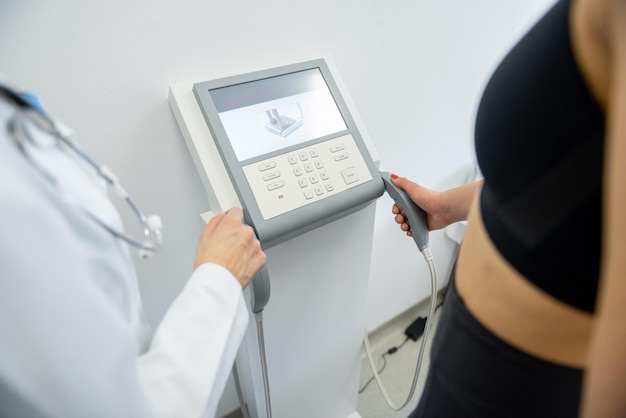 A woman undergoes a body composition analysis with a professional health expert