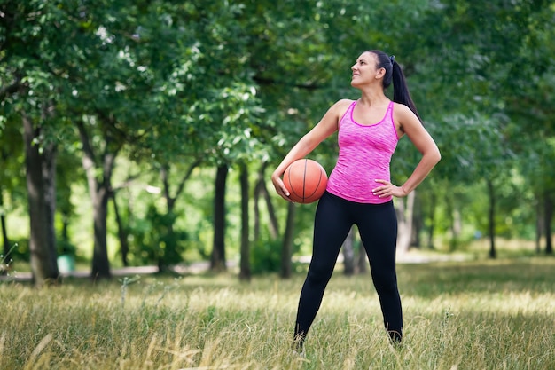 woman in uniform goes in for sports in the park with a ball.