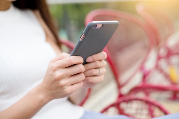 Woman use of phone under sunset at outdoor