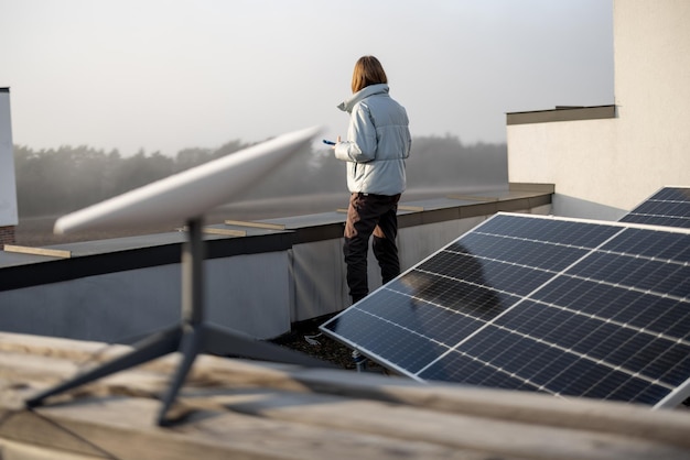 Woman uses satellite internet connection on roof of a house