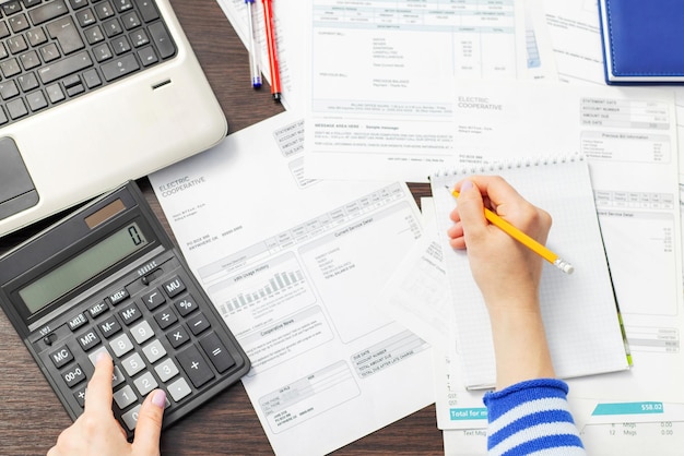 Woman using calculator for calculate domestic bills at home