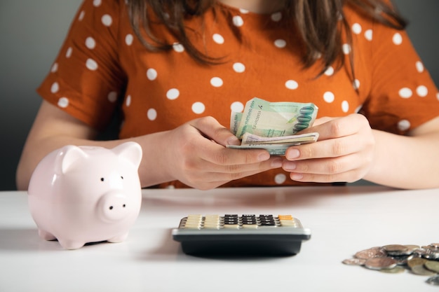 Woman using calculator and money