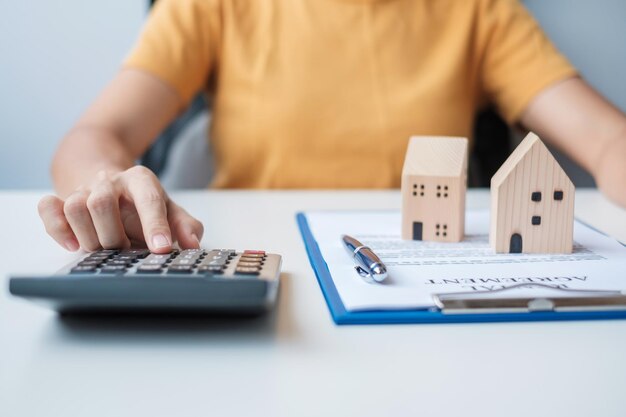 Woman using calculator during signing home contract documents Contract agreement real estate buy and sale and insurance concepts