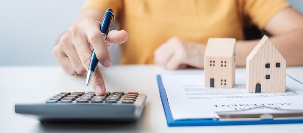 Woman using calculator during signing home contract documents Contract agreement real estate buy and sale and insurance concepts