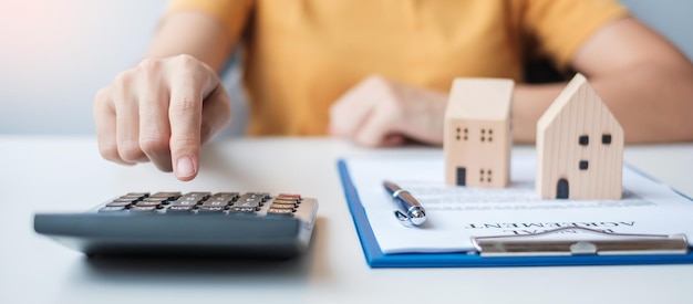 Woman using calculator during signing home contract documents Contract agreement real estate buy and sale and insurance concepts