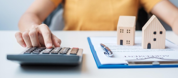 Woman using calculator during signing home contract documents Contract agreement real estate buy and sale and insurance concepts