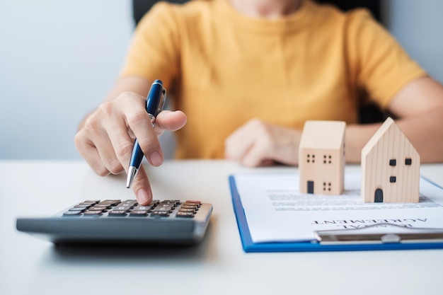 Woman using calculator during signing home contract documents Contract agreement real estate buy and sale and insurance concepts