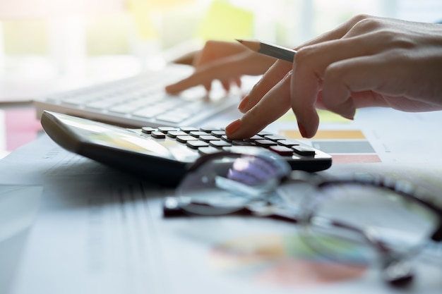 Woman using calculator while working for financial documents 