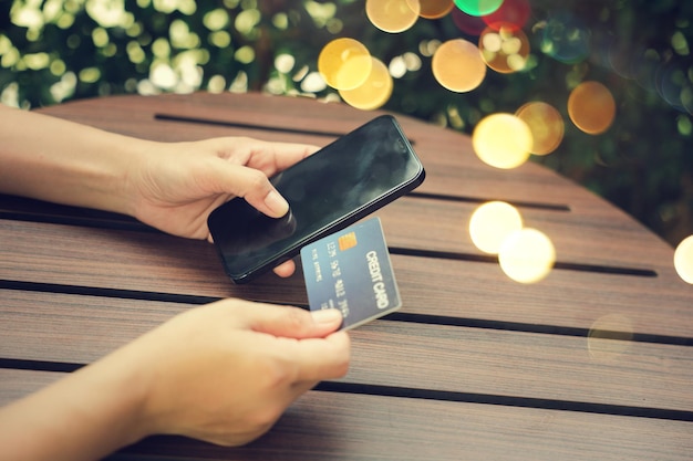 Woman using credit card and smartphone during slide screen for finding product