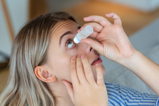 Woman using eye drop woman dropping eye lubricant to treat dry eye or allergy sick woman treating eyeball irritation or inflammation woman suffering from irritated eye optical symptoms