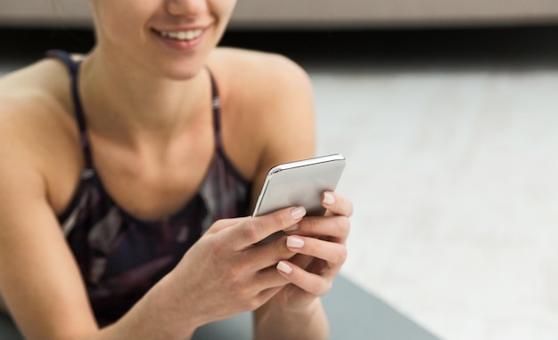 Woman using fitness app on her smartphone after workout