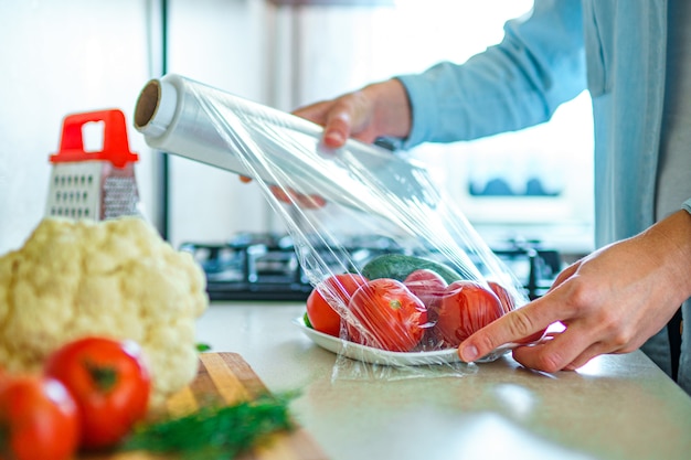 Woman using food film for food storage