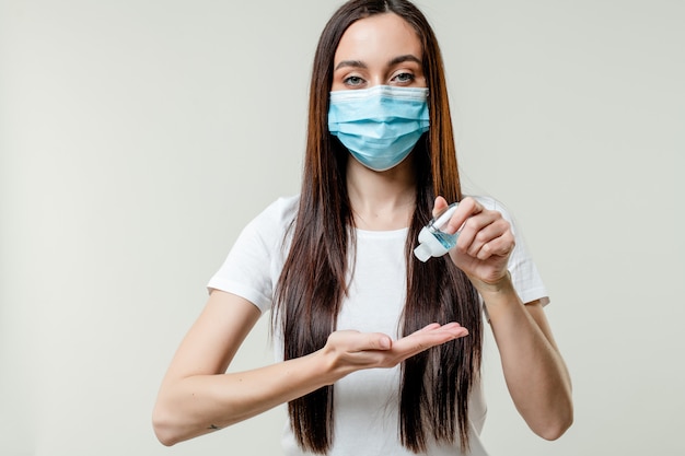 Woman using hand sanitizer wearing mask