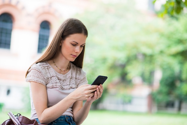 Woman using her mobile phone in a park