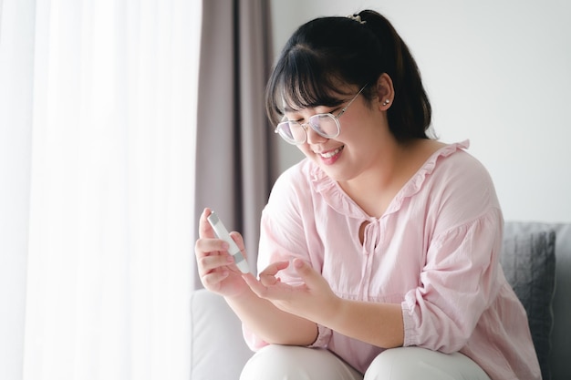 woman using lancet on finger for checking blood sugar level by Glucose meter diabetes Concept.