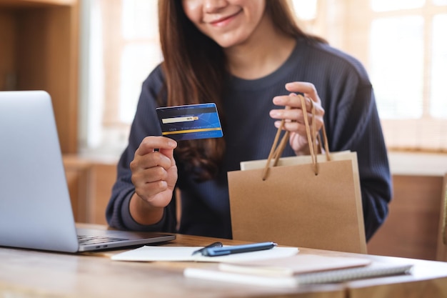 A woman using laptop computer and credit card for online shopping at home