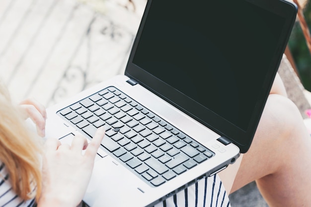 Woman using laptop computer outside the office. 