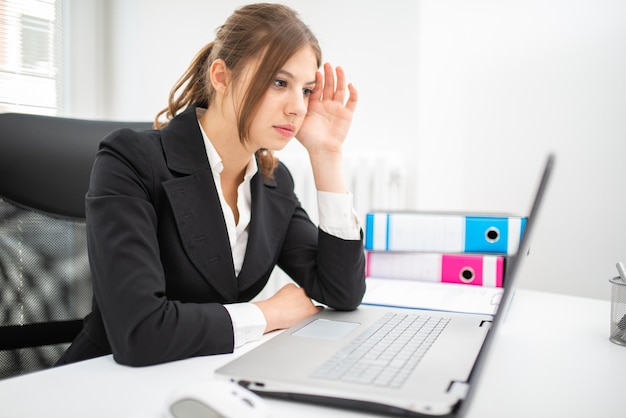 Woman using a laptop in her office