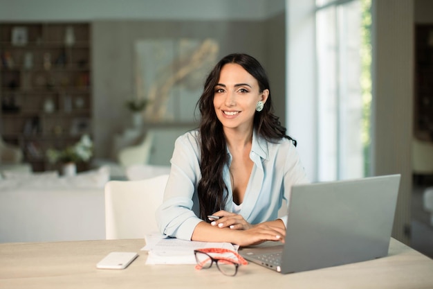 Woman using laptop indoors in home office