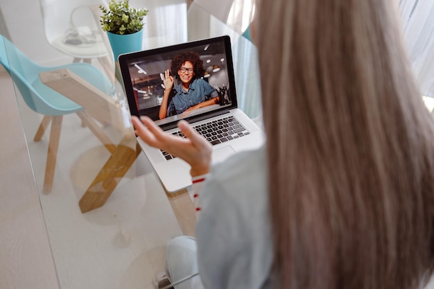 Woman using laptop for online communication with friend