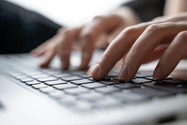 Woman using laptop, searching web, browsing information, having workplace at home