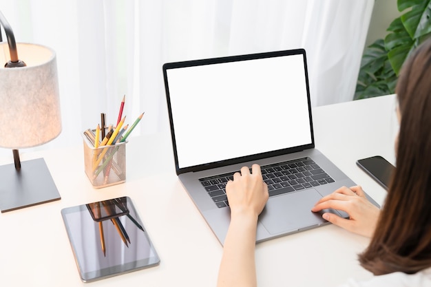 Woman using laptop with blank copy space screen for your advertisement.