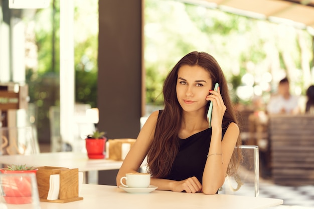 Woman Using Mobile Phone In cafe