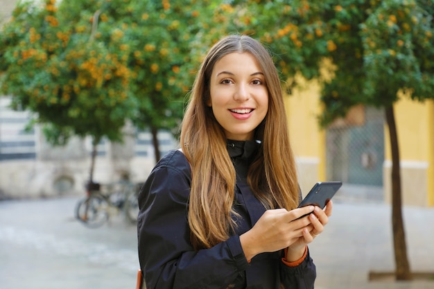 Woman using a mobile phone in city street