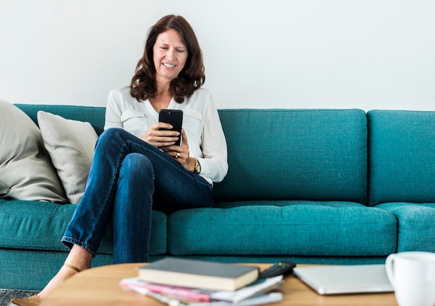 Woman using mobile phone on the sofa