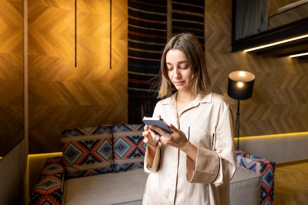 Woman using phone at modern apartment