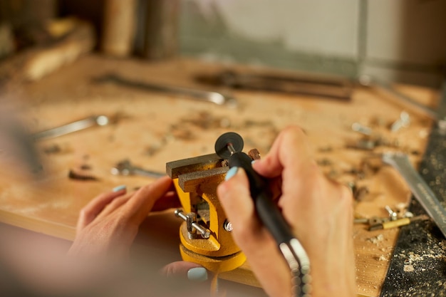 Woman using power working grinder machine female hand grinds a metal nuts