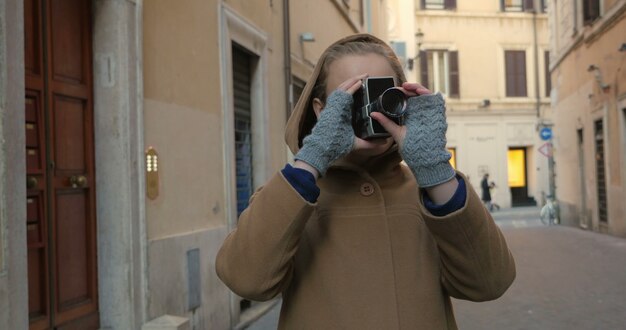 Woman using retro video camera in the street